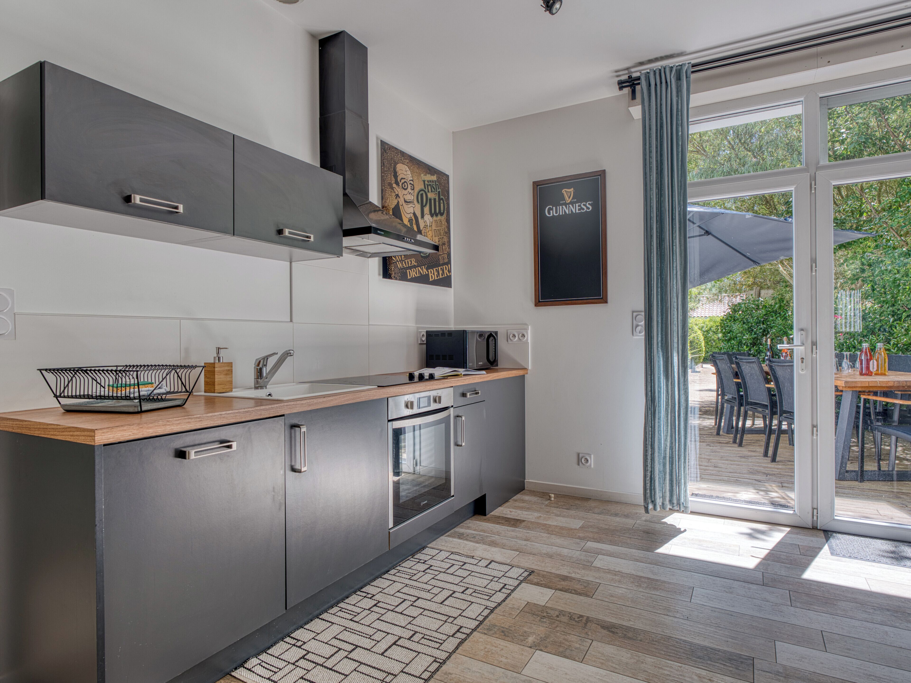 A modern kitchen with a built-in oven, microwave, and sink.