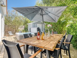 A wooden deck with a table, chairs, and a large umbrella. - Villa Irlande - Domaine Le Sherwood (Notre-Dame-De-Monts)