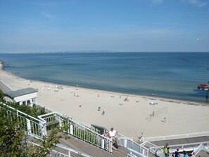 Ein Strand mit Promenadenweg und einem Rettungsturm.