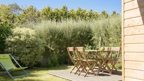 A wooden deck with a table and chairs, surrounded by dense shrubbery and trees. - House seafront, very quiet hamlet (Vicq-Sur-Mer)