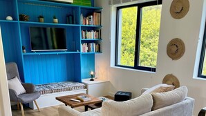 A living room with a sofa, a chair, a coffee table, a bookshelf, and a TV. - House seafront, very quiet hamlet (Vicq-Sur-Mer)