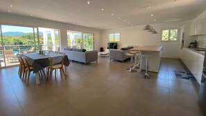 Amplia sala de estar con mesa de comedor, sofás y cocina.