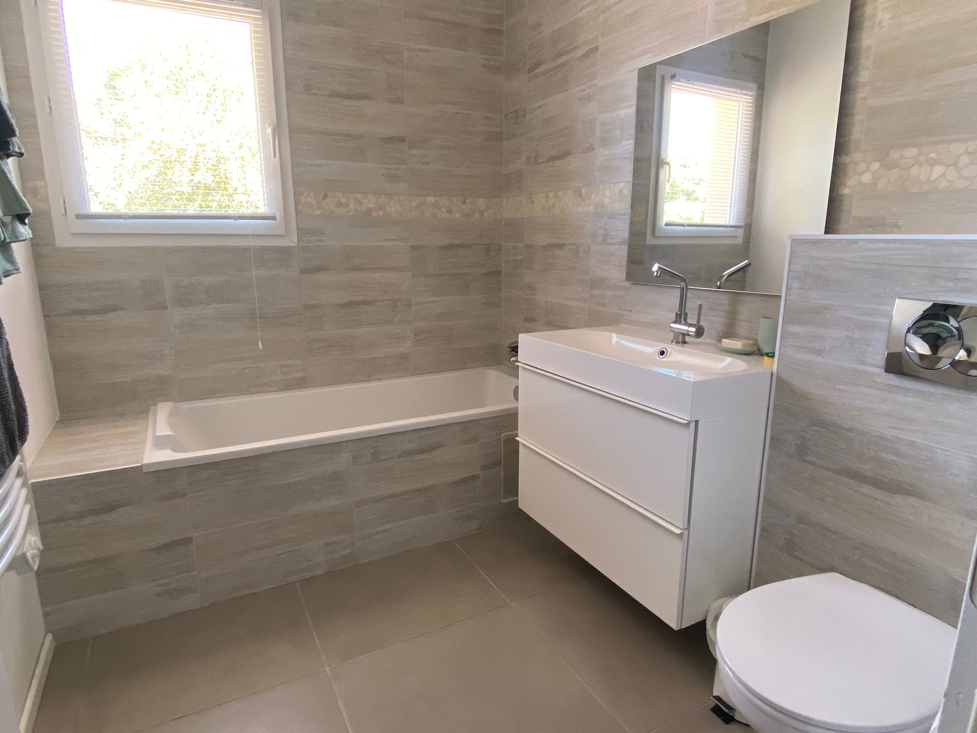 Une salle de bain moderne avec une baignoire, un lavabo et des toilettes.