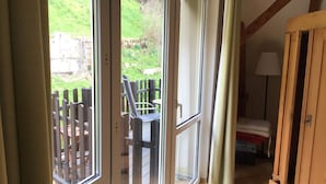 A room with a sliding glass door leading to an outdoor deck with a wooden fence and chairs. - Stylishly furnished apartment in Rathmannsdorf in the Zauketal, allergy sufferers (Rathmannsdorf)