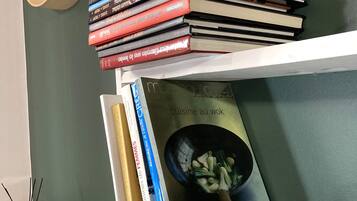 Une bibliothèque remplie de divers ouvrages, dont un livre intitulé « Marabout Cuisine au wok », qui est bien visible.