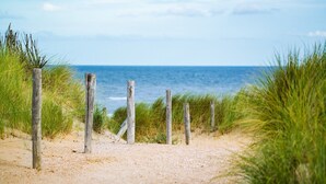 A sandy path with wooden posts and wire fencing leading to the ocean. - ☼ La Siesta ☼ Character house with garden and terraces ☼ (La Rochelle)