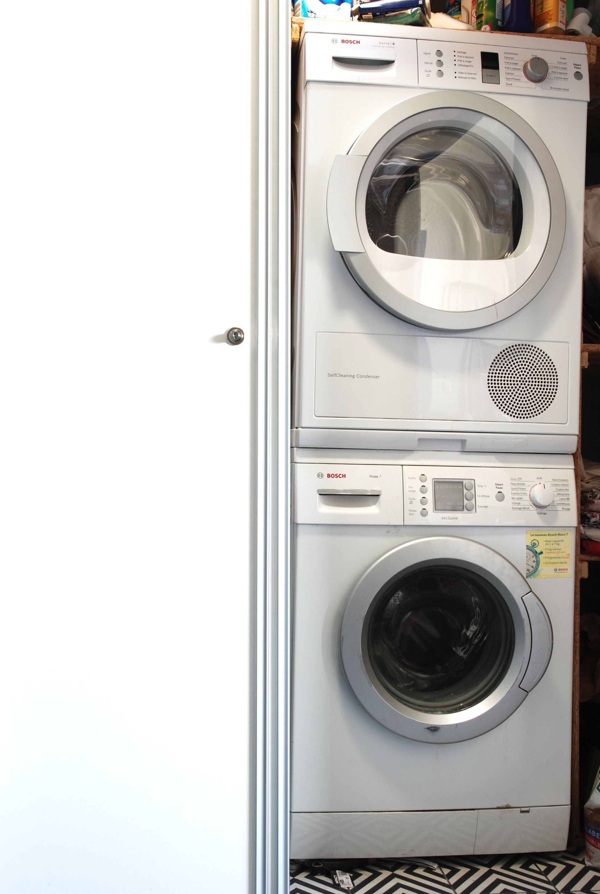 A stacked Bosch washing machine with a self-cleaning condenser and a Maxx 7 model below it.