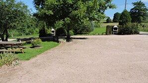 A gravel parking area with picnic tables and a gazebo. - Rental cottage in renovated farm (Arrentès-De-Corcieux)