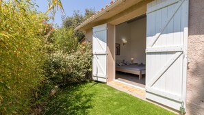 A room with a bed, a nightstand, and a wall-mounted lamp. - Félyvonne, family villa with sea and vineyard view (Hyères)