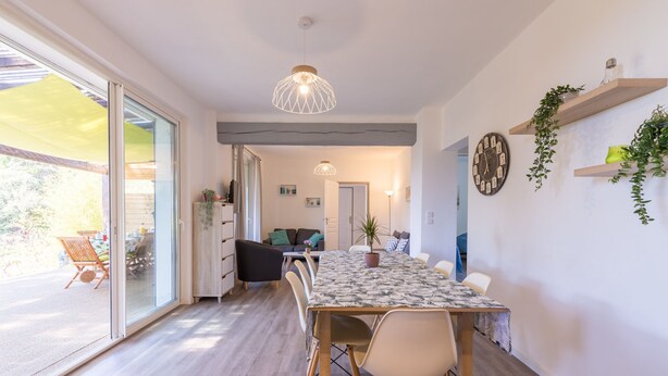 A dining area with a long table, chairs, and a hanging light fixture. - Félyvonne, family villa with sea and vineyard view (Hyères)