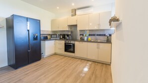 A modern kitchen with a black refrigerator, a microwave, a coffee maker, and a stove. - Félyvonne, family villa with sea and vineyard view (Hyères)