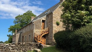 Un bâtiment en pierre avec un escalier en bois menant à un étage supérieur.