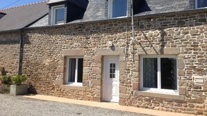 A two-story stone building with a sloped roof, two windows on the ground floor, and a door. - House *** in Mont Saint Michel bay for 2 to 6 people  (Saint-Broladre)