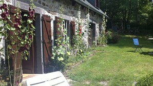 A stone building with wooden shutters and a grassy yard. - Old farmhouse restored warm decoration comfortable on a 3ha plot (Saint-Donat)