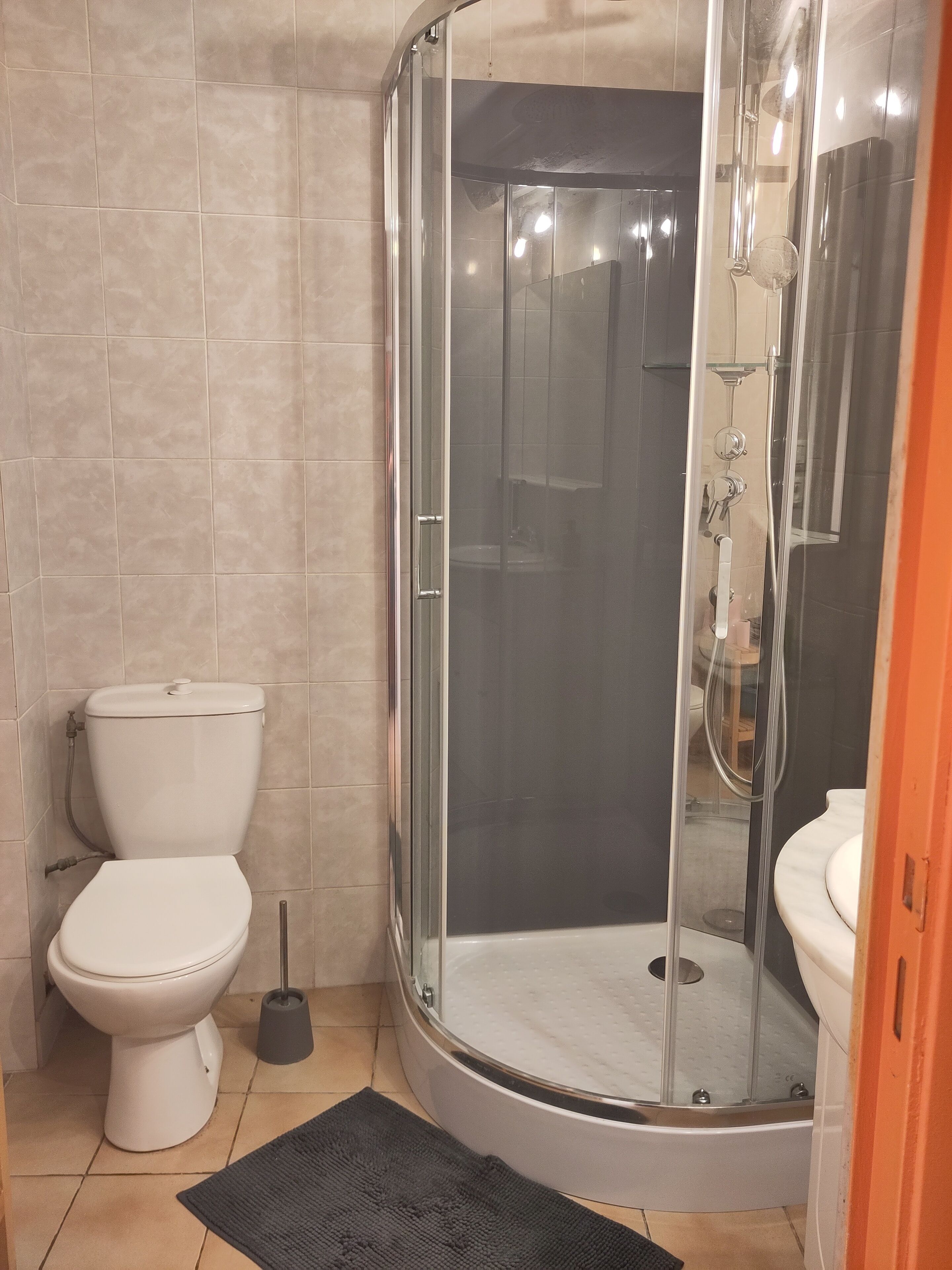 A bathroom with a glass-enclosed shower, a toilet, and a bidet.