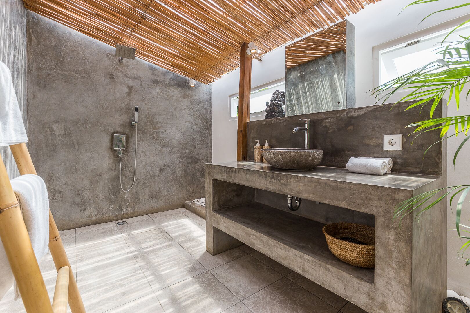 Une salle de bain moderne avec une douche en béton, un grand miroir et un plafond en bois.