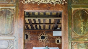 A rustic wooden room with a bed, decorative wall mirrors, and a woven ceiling light fixture. - Villa Langka Harmony and calm in Seminyak Oberoi (Seminyak)