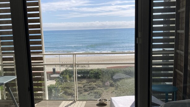 A balcony with a view of the ocean, a bed, and a table. - F1 1ST LINE EXCEPTIONAL SEA VIEW (Palavas-Les-Flots)