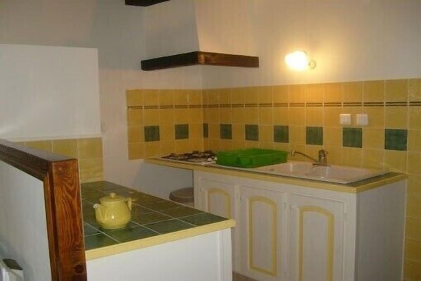 A kitchen with a green countertop, a sink, and a yellow-tiled backsplash. - Quiet cottage with beautiful view (Chirols)