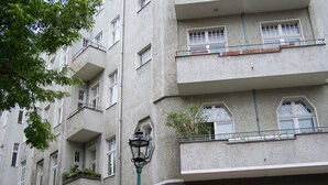 Ein mehrstöckiges Gebäude mit Balkonen, Fenstern und einer Straßenlaterne.