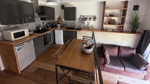 A modern kitchen with a dining area, a built-in oven, a microwave, and a sink. - Small independent apartment in farmhouse with air conditioning (Chavanod)
