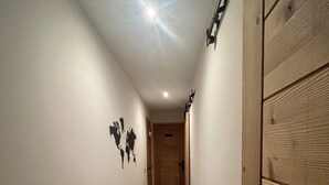 A narrow hallway with wooden flooring and white walls. - Small independent apartment in farmhouse with air conditioning (Chavanod)