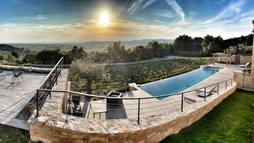 Een buitenzwembad en een infinitypool