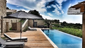 Een buitenzwembad en een infinitypool