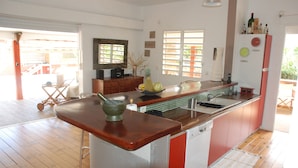 Una cocina con encimera de madera, un lavamanos y un refrigerador.