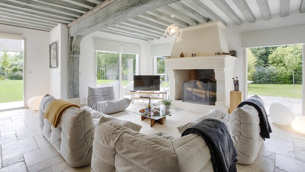 Un salón amplio con chimenea, asientos cómodos y televisor.