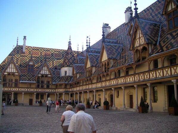 A courtyard with a traditional European building featuring a tiled roof and timber framing.
