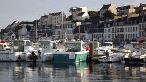 A marina with several boats docked, surrounded by buildings with balconies and windows. - House downtown, PORT DE PLAISANCE d'AUDIERNE, wifi (Audierne)
