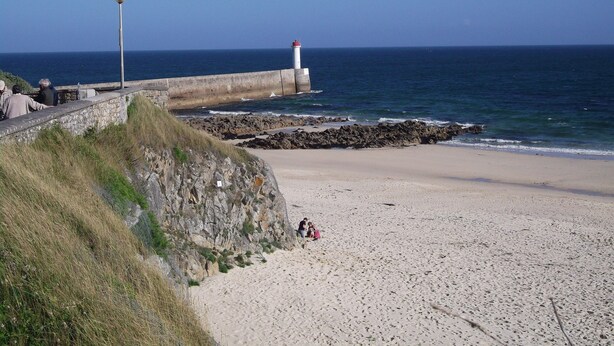 A coastal beach with a lighthouse, rocky shoreline, and a stone wall. - House downtown, PORT DE PLAISANCE d'AUDIERNE, wifi (Audierne)