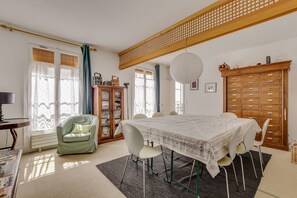 A dining area with a table, chairs, a cabinet, and a chair.
