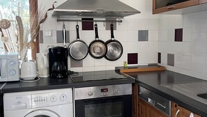 A compact kitchen with a washing machine, oven, and stove. - Bungalow, enclosed garden, direct beach access (La Turballe)