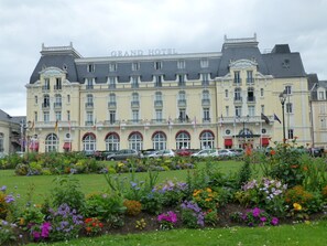 Un gran edificio de hotel con varios balcones y un jardín delantero.