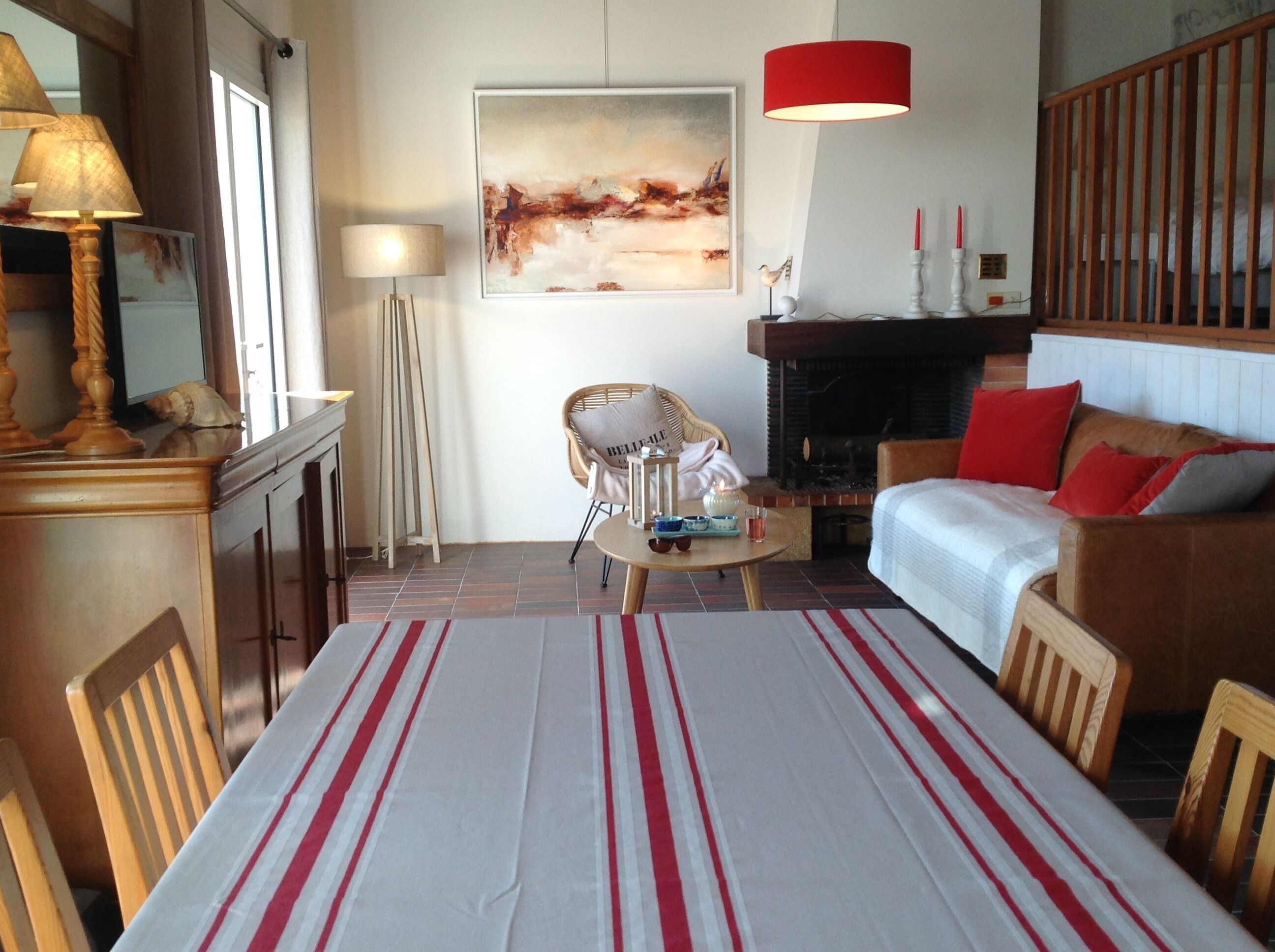 Un salon comprenant une table à manger, un canapé, une cheminée et un tableau accroché au mur.