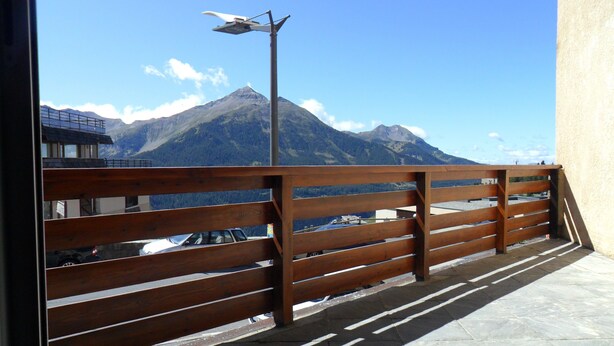 A balcony with a wooden railing overlooking a mountainous landscape. - Holiday Apartment (Orcières)