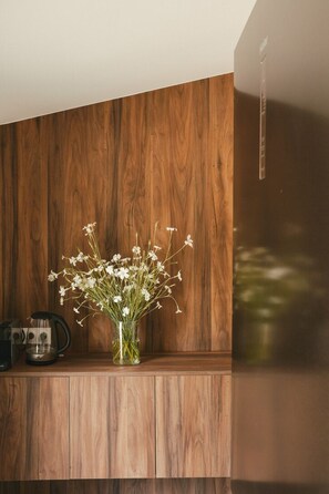 A wooden cabinet with a vase of white flowers. - Le Manoir du Four à Chaux (Paimpol)