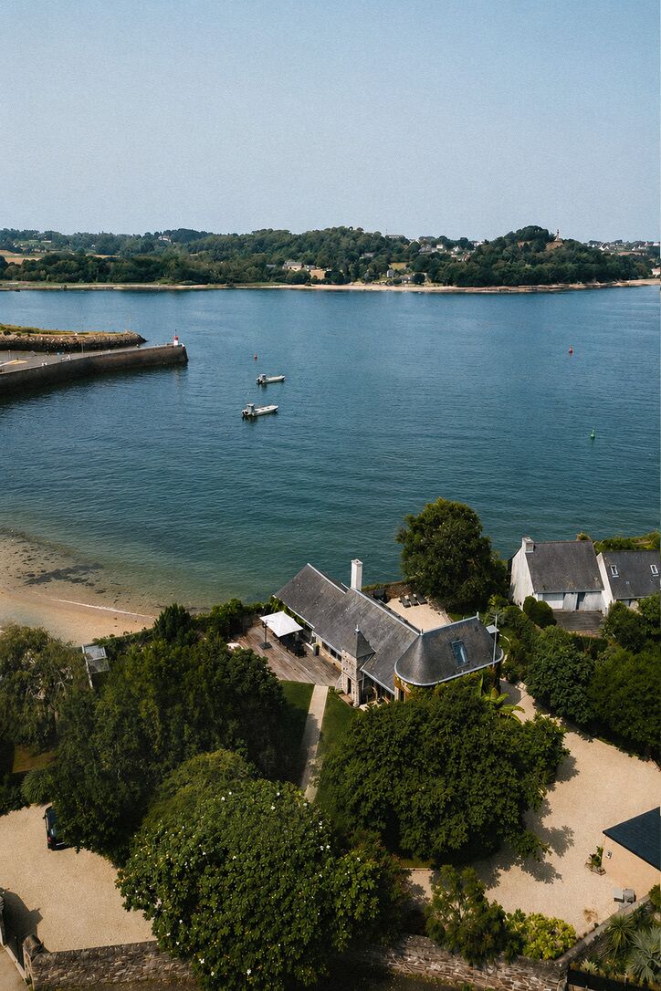 Une propriété située sur la côte, avec une plage, une jetée et des bateaux.