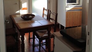 Une cuisine de taille réduite comprenant une table à manger, des chaises, un four à micro-ondes et un réfrigérateur.