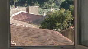 A view from a window overlooking a coastal area with a clear sky, a body of water, and greenery. - Charming house in medieval village with pond view terrace, private parking (Miramas)