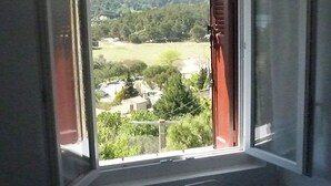 A bedroom with a window overlooking a green landscape. - Charming house in medieval village with pond view terrace, private parking (Miramas)