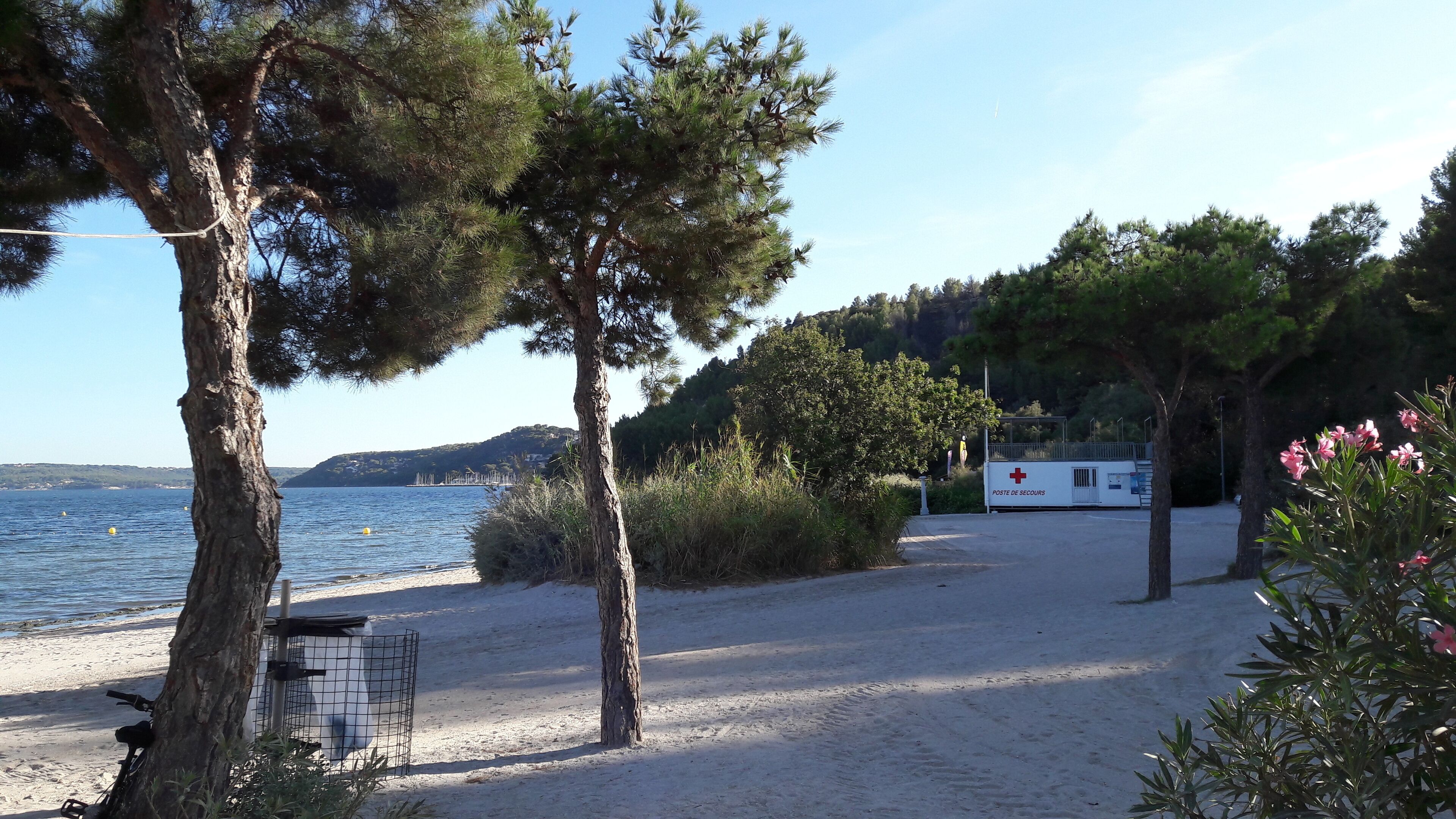 A beach with a medical facility in the background.