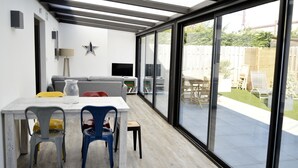 Un espace patio moderne comprenant une table à manger, des chaises et un canapé.