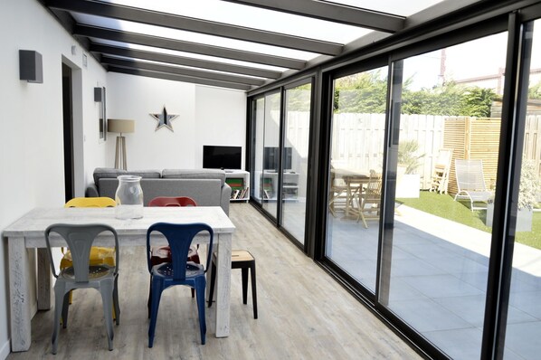 Un patio moderno con mesa, sillas y sofá.