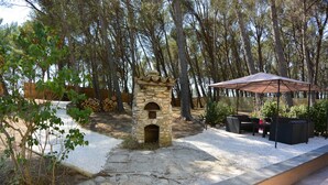 A stone-built outdoor area with a seating arrangement and a covered patio.
