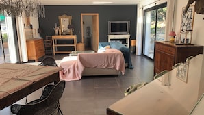 Una sala de estar moderna con sofá, mesa de comedor y televisor.