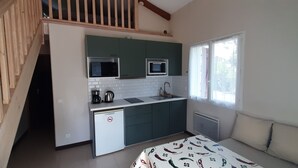 A compact kitchen with a microwave, coffee maker, and sink, a small refrigerator, and a window with curtains. - Bidart, pretty apartment for 4 people, close to beaches and center of Guéthary  (Bidart)