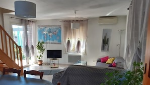 Un salon confortable avec un lit, un téléviseur et un coin repas.